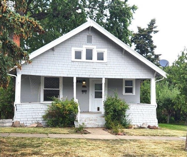 bungalow-style house featuring a front lawn and covered porch