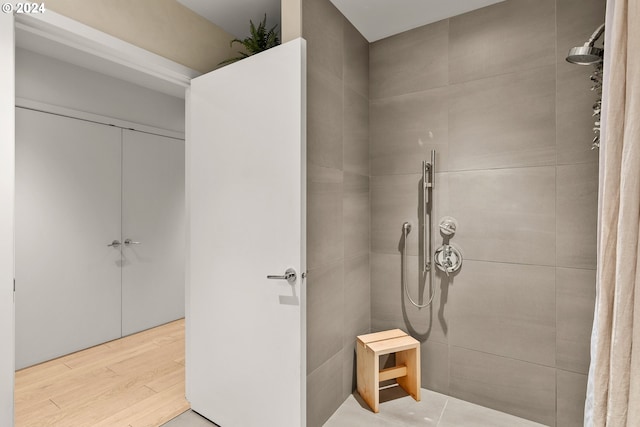 1150 NW Quimby St Unit 208, Portland, OR 97209 - bathroom featuring tiled shower and wood finished floors