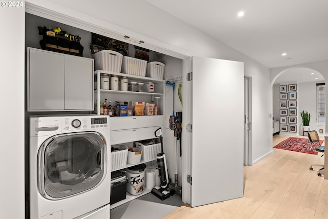 1150 NW Quimby St Unit 208, Portland, OR 97209 - laundry room featuring washer / dryer, arched walkways, cabinet space, recessed lighting, and light wood finished floors