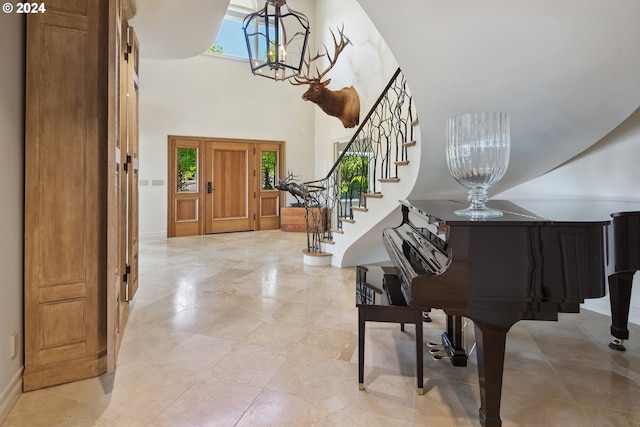 entryway with an inviting chandelier and a towering ceiling