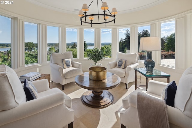 sunroom featuring a chandelier and a water view