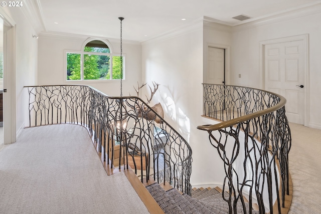 stairs with a notable chandelier, ornamental molding, and carpet