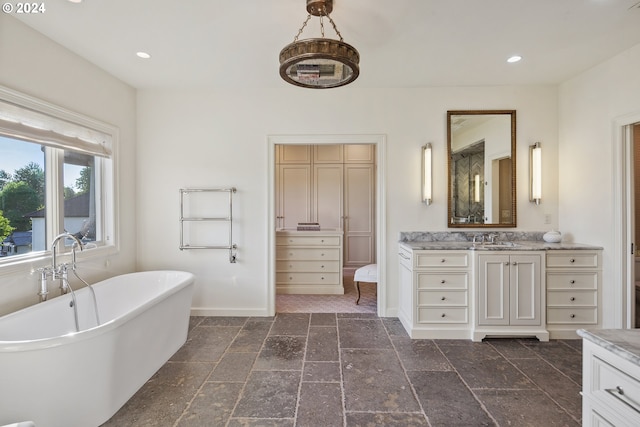 bathroom with a tub to relax in and vanity