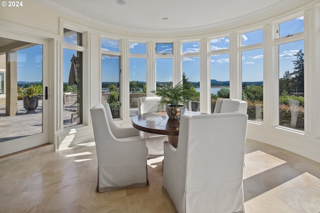 sunroom featuring a water view