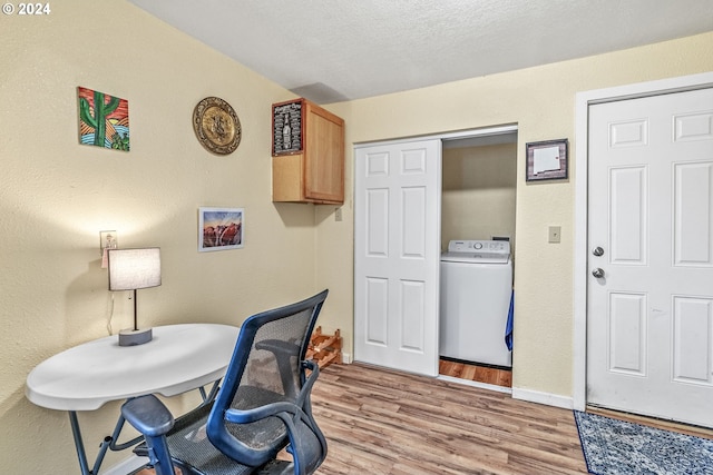 home office with a textured ceiling, washer / clothes dryer, and light hardwood / wood-style flooring