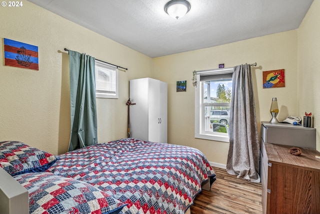 bedroom featuring hardwood / wood-style floors and a textured ceiling