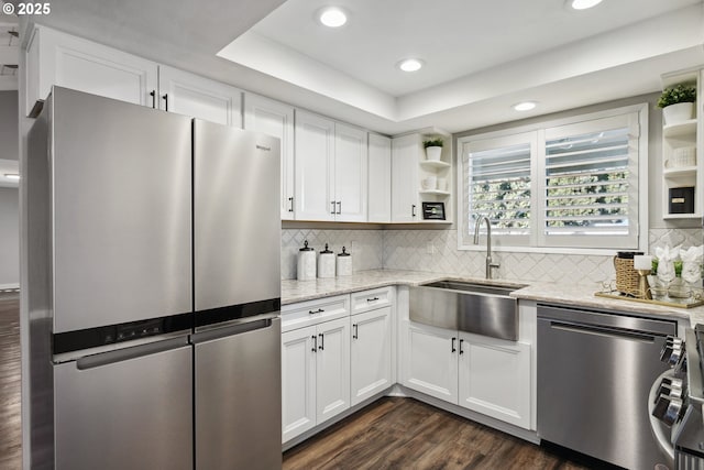 kitchen featuring stainless steel appliances, sink, white cabinets, and light stone counters