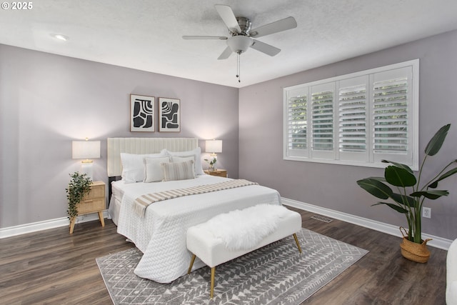 bedroom featuring dark hardwood / wood-style flooring, a textured ceiling, and ceiling fan