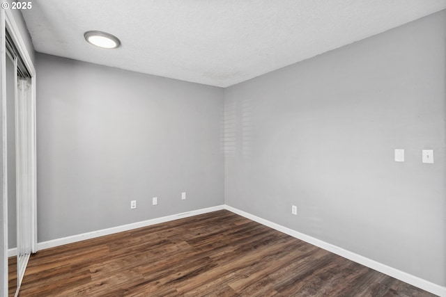 unfurnished room featuring dark hardwood / wood-style floors and a textured ceiling