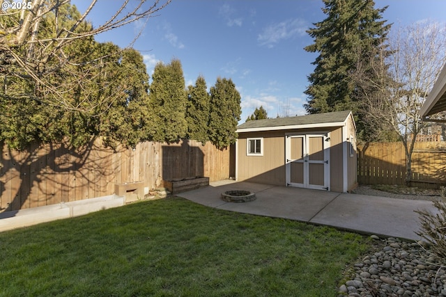 view of yard featuring a storage unit, a patio area, and a fire pit