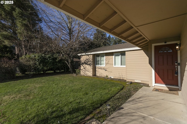 property entrance featuring a patio and a lawn