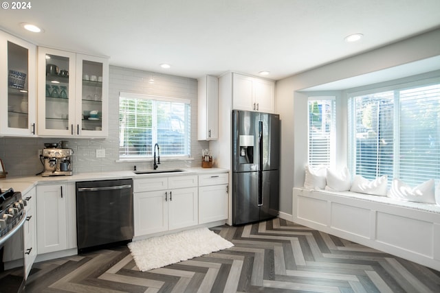 kitchen with decorative backsplash, a wealth of natural light, sink, and stainless steel appliances