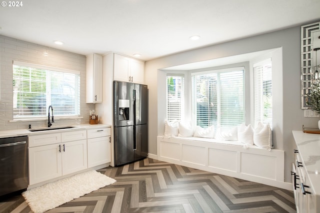 kitchen featuring sink, dark parquet floors, backsplash, white cabinets, and appliances with stainless steel finishes