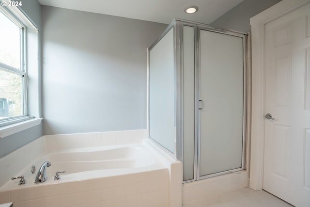 bathroom with a healthy amount of sunlight and separate shower and tub