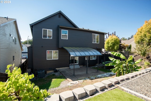 back of property with central AC and a patio area