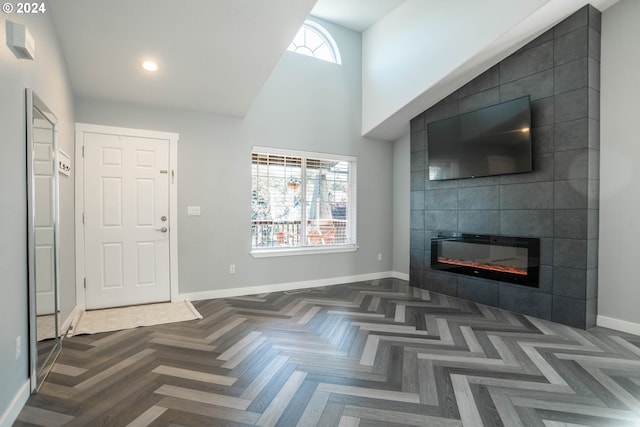 living room with a tile fireplace, dark parquet floors, and tile walls