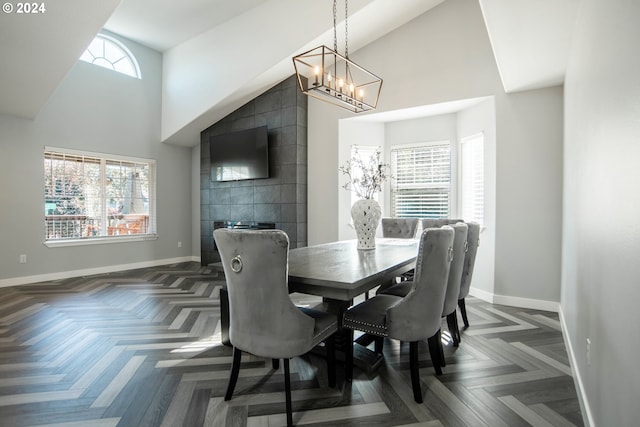 dining area featuring a wealth of natural light, dark parquet floors, and an inviting chandelier