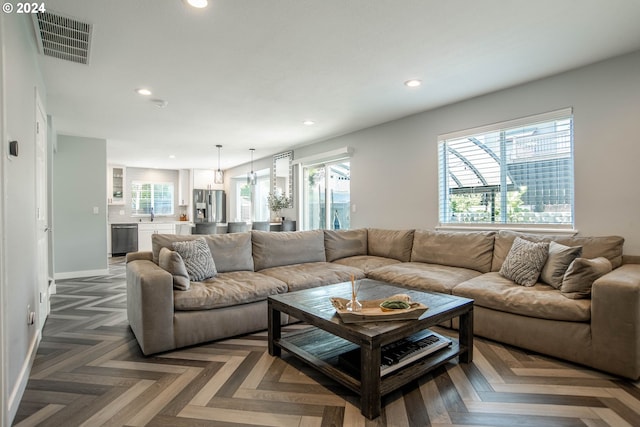 living room with dark parquet floors and a healthy amount of sunlight