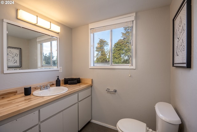 bathroom with vanity, toilet, and a wealth of natural light