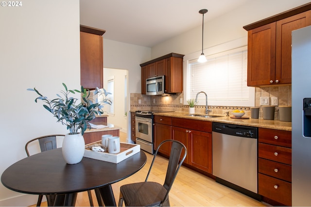 kitchen featuring tasteful backsplash, appliances with stainless steel finishes, sink, and light stone countertops