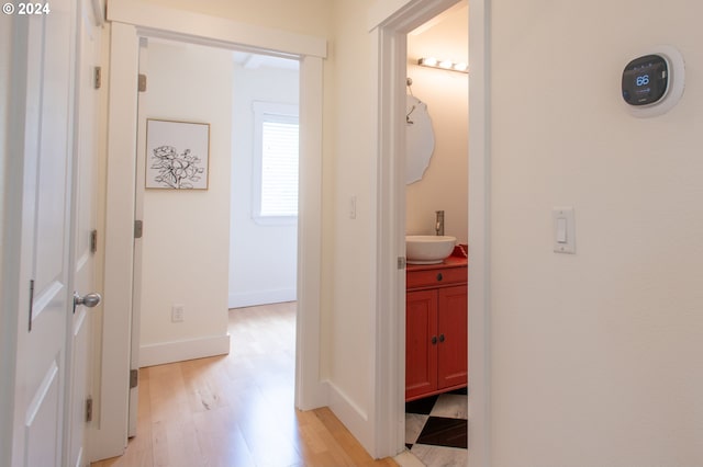 hall with sink and light wood-type flooring