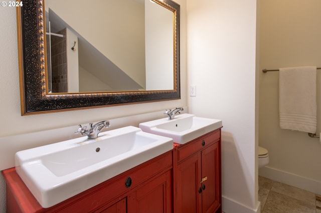 bathroom with tile flooring, vanity with extensive cabinet space, toilet, and double sink