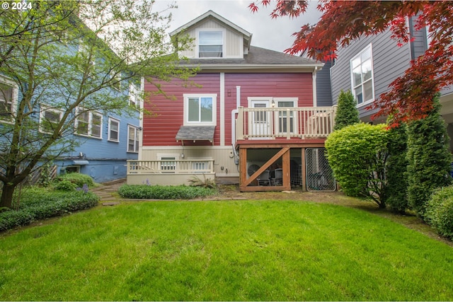 rear view of house featuring a deck and a yard