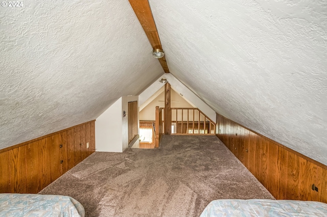 additional living space featuring a textured ceiling and vaulted ceiling