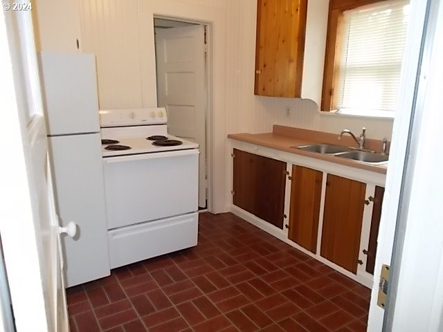 kitchen featuring white appliances and sink