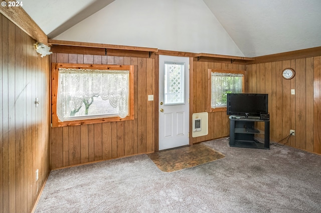 carpeted entryway featuring wood walls, heating unit, and high vaulted ceiling