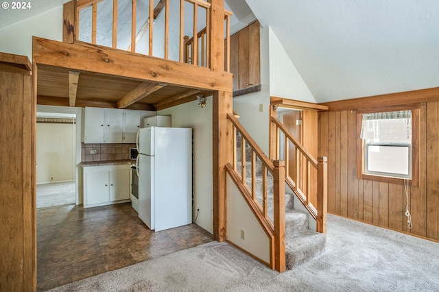 kitchen with carpet floors, tasteful backsplash, high vaulted ceiling, white fridge, and white cabinetry