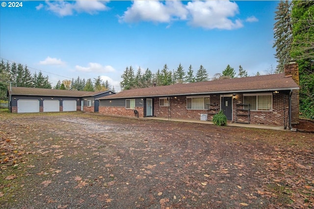 single story home with an outbuilding, a porch, and a garage