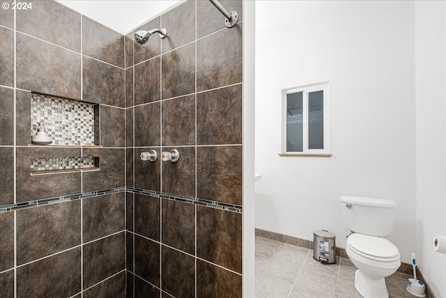 bathroom with tile patterned floors, toilet, and tiled shower