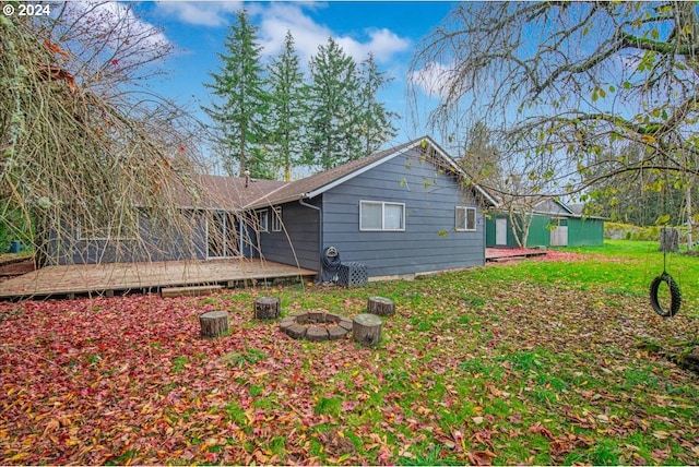 view of side of home featuring a deck and an outdoor fire pit