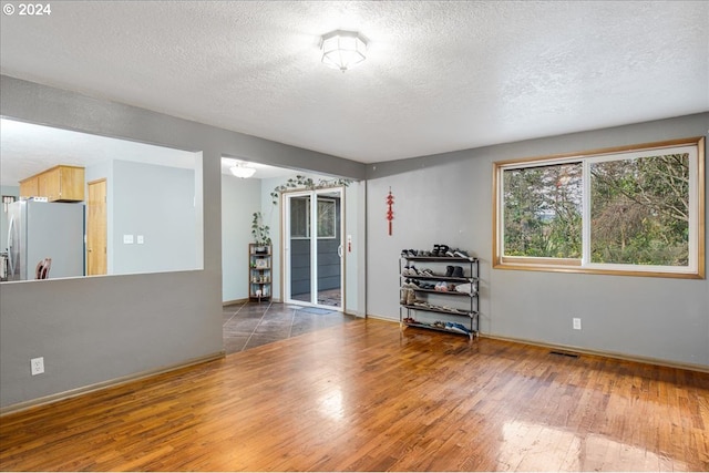 spare room with dark wood-type flooring and a textured ceiling