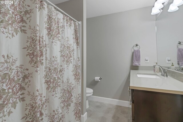 bathroom with tile patterned flooring, vanity, toilet, and walk in shower