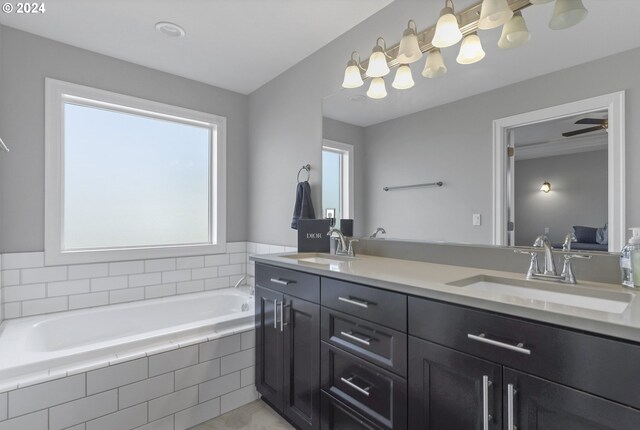 bathroom featuring vanity, a relaxing tiled tub, and ceiling fan