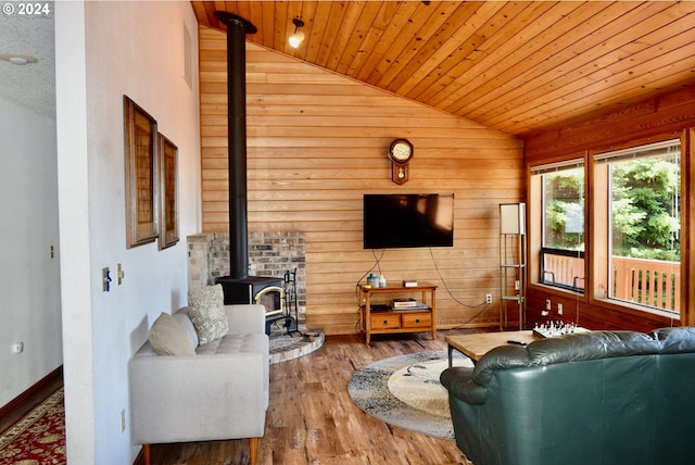 living room featuring wooden ceiling, hardwood / wood-style floors, a wood stove, lofted ceiling, and wood walls