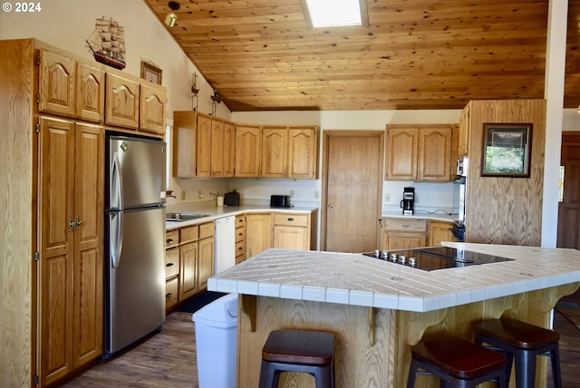 kitchen with black electric stovetop, wood ceiling, vaulted ceiling, tile countertops, and stainless steel refrigerator