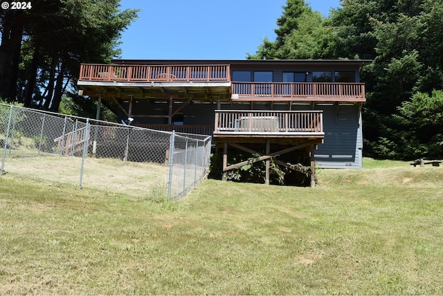 rear view of property with a yard and a wooden deck