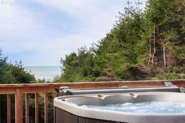 exterior space featuring a water view and a hot tub