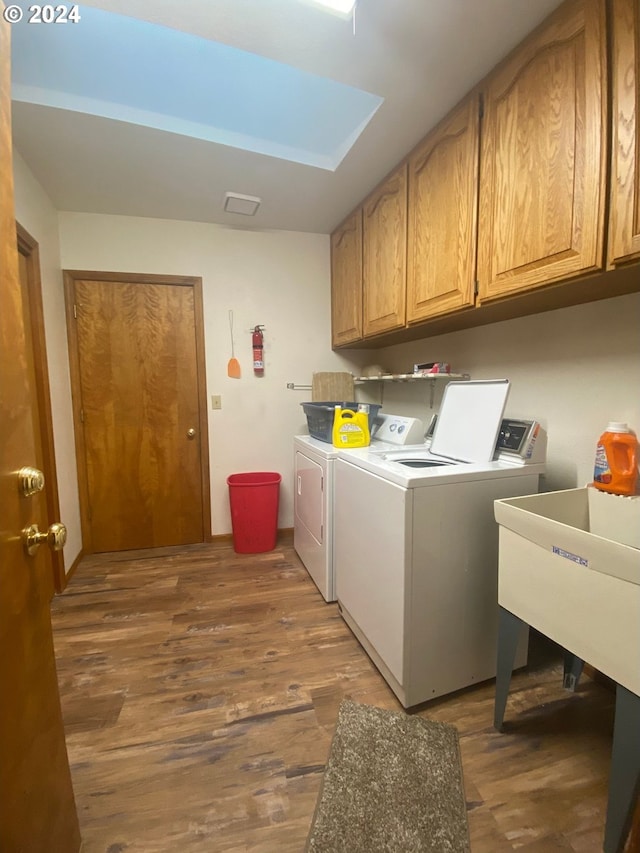 washroom featuring dark hardwood / wood-style flooring, cabinets, and independent washer and dryer