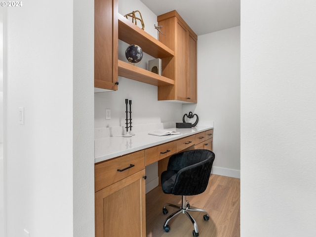 office with built in desk and wood-type flooring