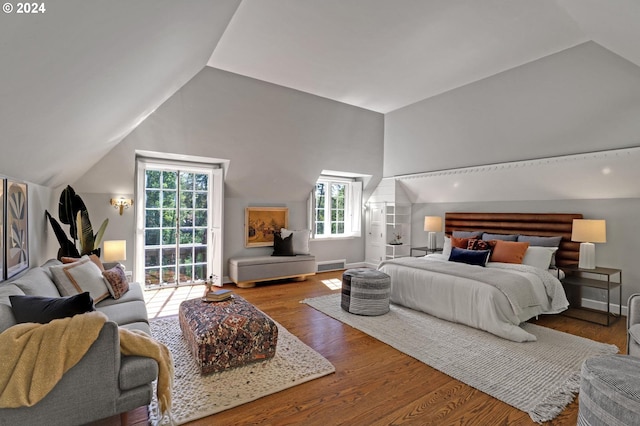 bedroom featuring vaulted ceiling, wood finished floors, visible vents, and baseboards