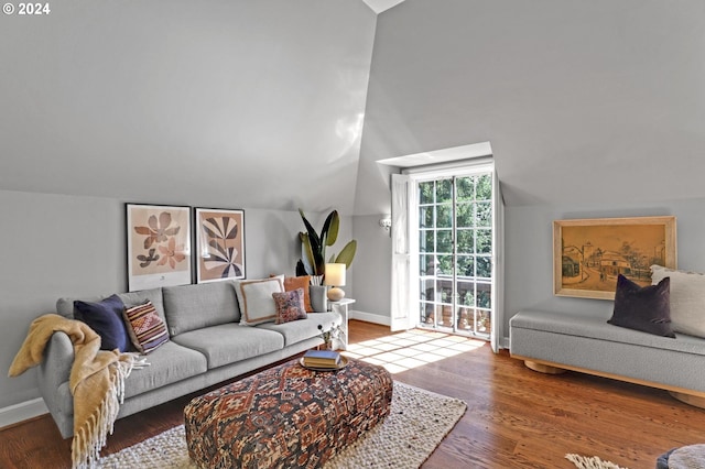 living area with lofted ceiling, wood finished floors, and baseboards