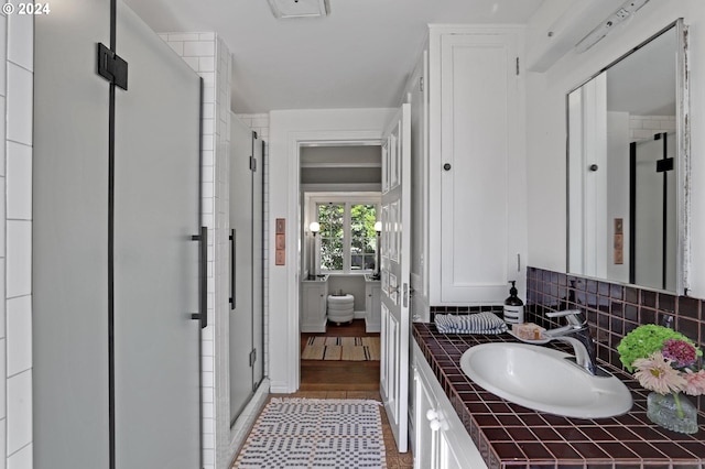 bathroom featuring a stall shower, tasteful backsplash, and vanity