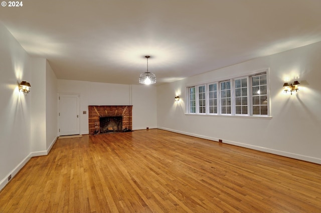 unfurnished living room with wood-type flooring, a fireplace, and baseboards