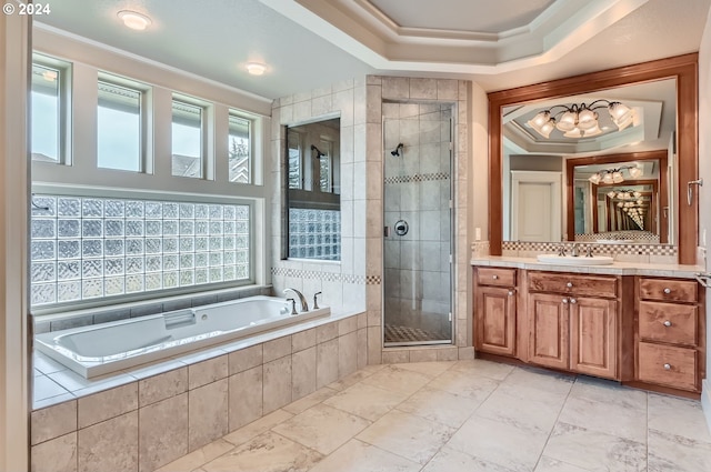 bathroom with independent shower and bath, vanity, a tray ceiling, and ornamental molding