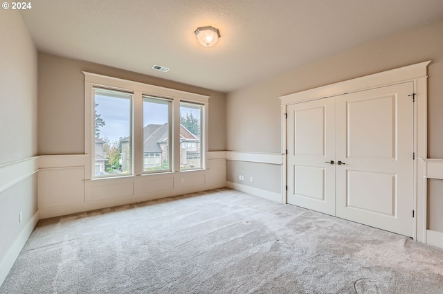 unfurnished bedroom featuring light carpet