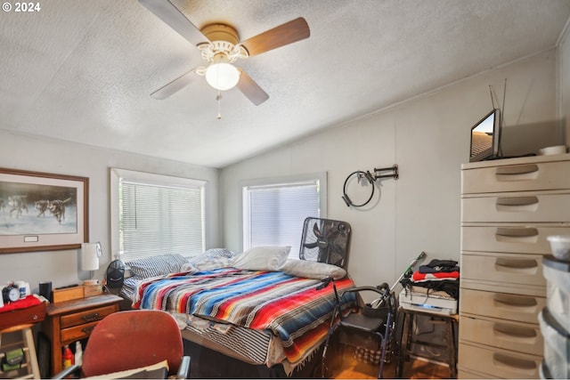 bedroom featuring vaulted ceiling, a textured ceiling, and ceiling fan